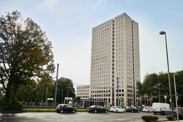 Der Westfalentower an einer befahrenen Straße bei sonnigem Wetter.