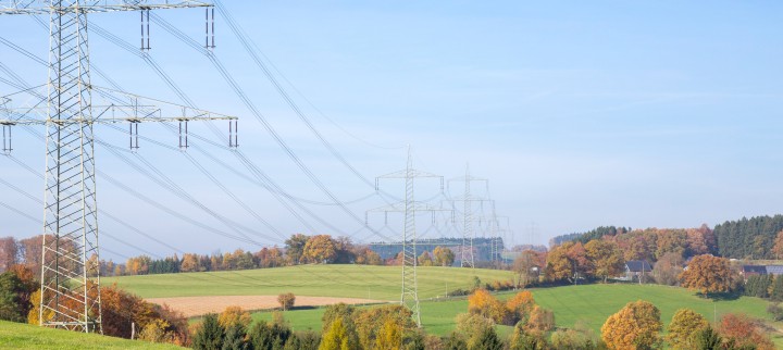 Das freundliche Foto im Querformat  zeigt eine Trasse in hügeliger und grüner Landschaft unter einem blauen Himmel.