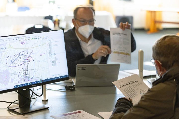 Zwei Männer besprechen Planungsunterlagen zu den Offshore-Projekten DolWin3 und BorWin4 an einem Tisch mit Monitor.