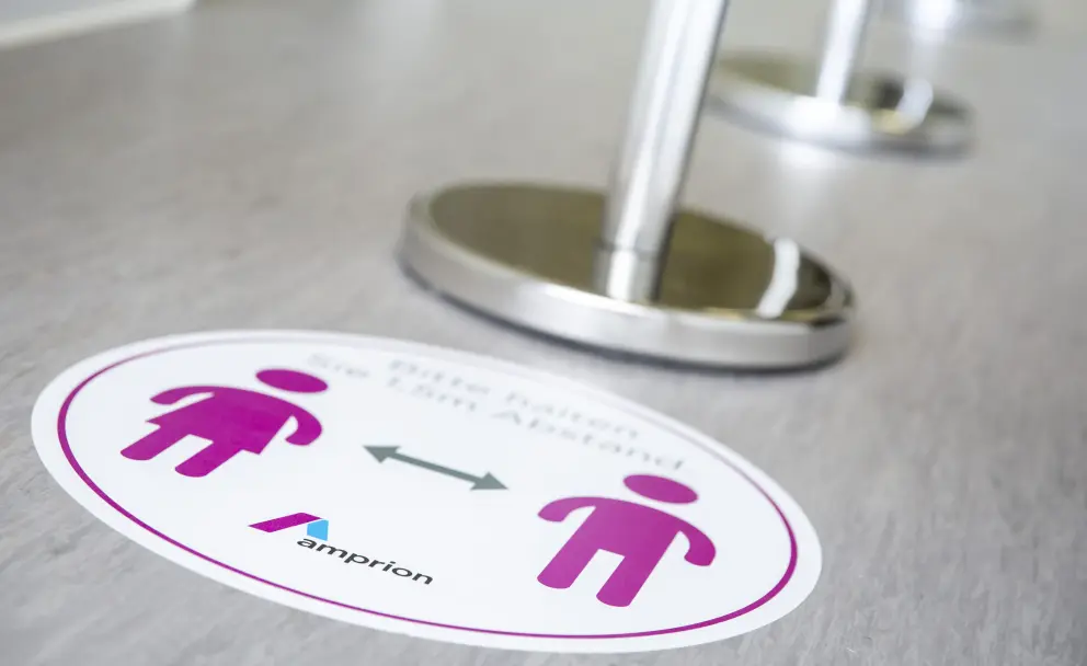 Bitte halten Sie 1,5m Abstand mit Amprion-Logo.