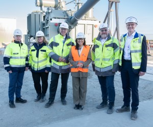 Amprion CEO Christoph Müller,  Bundesministerin für Wirtschaft und Energie Katherine Reiche und eine Gruppe von Menschen in In Schutzkleidung vor einem großen Gerät