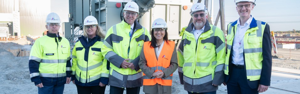 Amprion CEO Christoph Müller,  Bundesministerin für Wirtschaft und Energie Katherine Reiche und eine Gruppe von Menschen in In Schutzkleidung vor einem großen Gerät