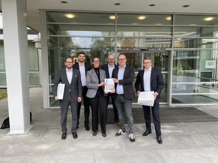 Das Bild zeigt das A-Nord-Projektteam von Amprion mit Verantwortlichen der Bundesnetzagentur in Bonn bei der Entgegennahme von Planfeststellungsbeschlüssen für Abschnitte der A-Nord-Erdkabeltrasse. 