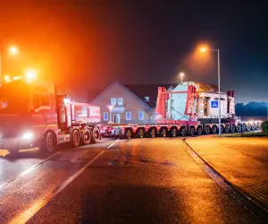 Ein großer Transformator wird nachts auf einem Selbstfahrer-Modultransporter (SPMT) transportiert.