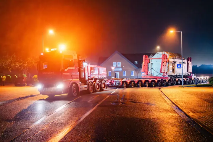 Ein großer Transformator wird nachts auf einem Selbstfahrer-Modultransporter (SPMT) transportiert.