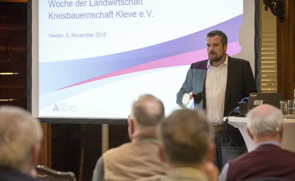 Das Bild zeigt einen Mann, der einen Vortrag hält im Rahmen der Veranstaltung "Woche der Landwirtschaft" der "Kreisbauernschaft Kleve e.V.". Die Veranstaltung fand am 6. November 2018 in Heiden statt. 