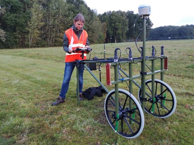 Frau mit Wanrweste vor einem Oberflächendetektor mit an einem Handschlitten montierten Georadar-Sensoren
(c) CDM Smith