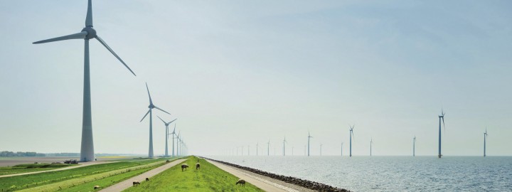Windkraftanlagen am Ufer und auf dem Wasser