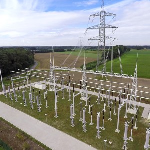 Das Foto zeigt die Kabeluebergabestation Loechte. Sechs Leiterseile führen von einem Strommasten in die Station.