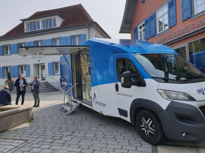 Das Infomobil steht auf einem gepflasterten Marktplatz.