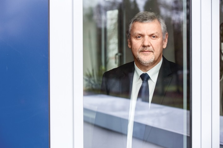 Das Bild zeigt eine Person, die hinter einer großen Glasscheibe steht.