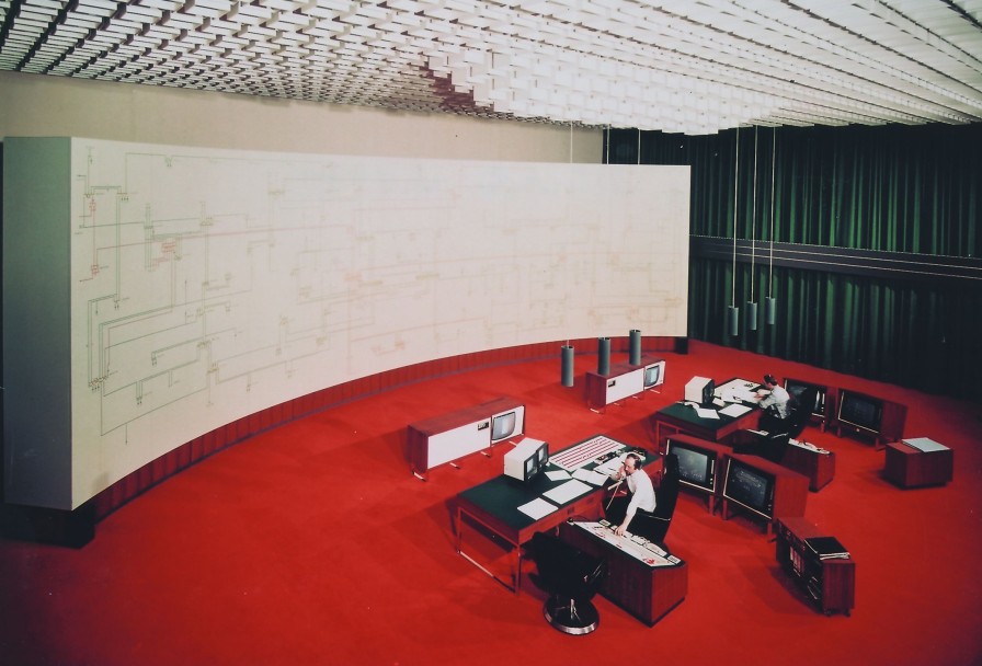 Das Bild ist in den 1970er-Jahren in der Hauptschaltleitun entstanden. Ein analoges Rückmeldebild, davor zwei Computerarbeitsplätze. Der Boden ist mit rotem Teppich versehen.