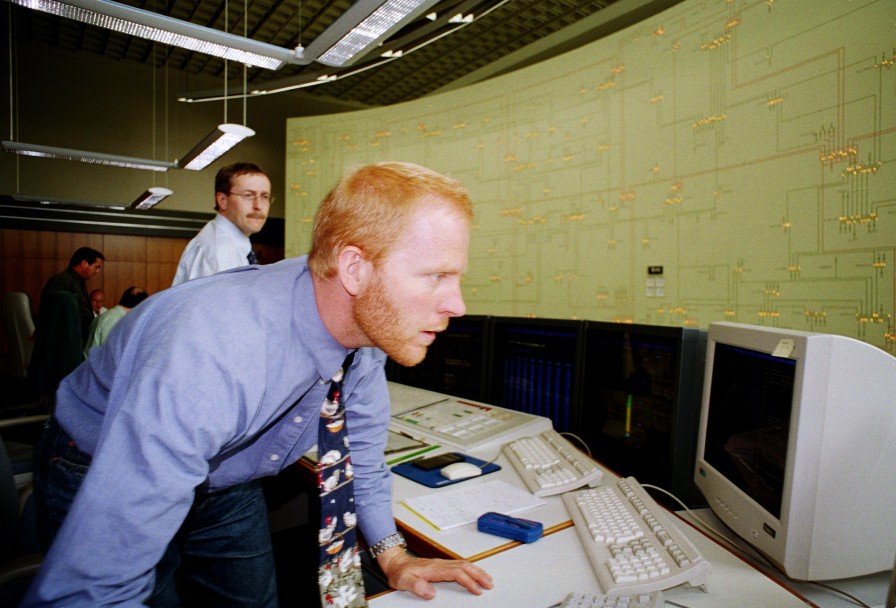 Das Bild zeigt zwei Schaltingenieure vor einem analogen Rückmeldebild.