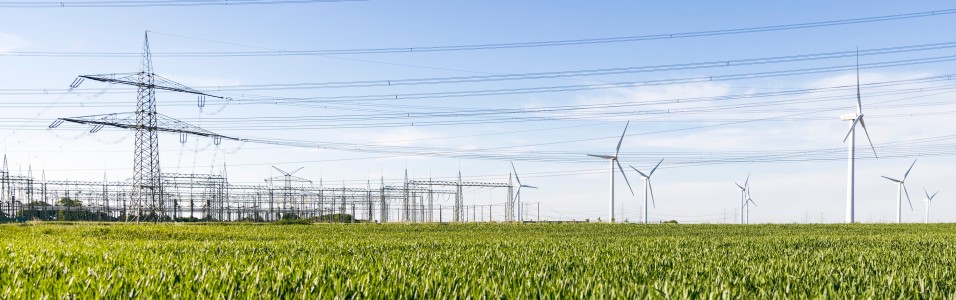 Freileitung, Höchstspannungsmast und Windräder an der Amprion-Umspannanlage Rommerskirchen, aufgenommen im Frühling