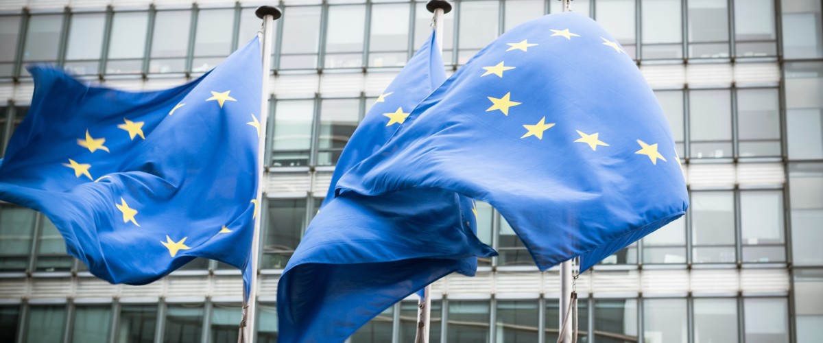 Drei Masten mit wehenden Europafahnen vor dem europäischen Parlamant.