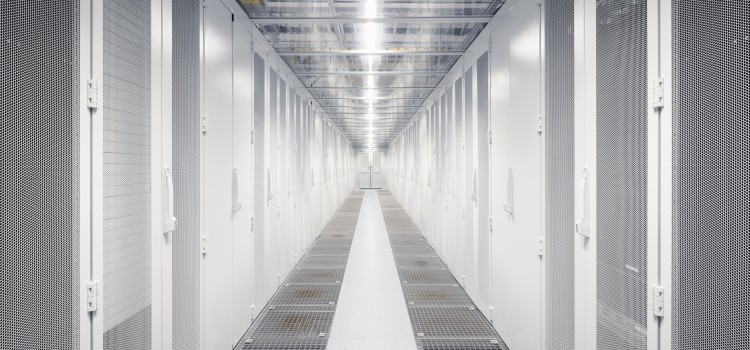 Blick in einen hellbeleuchteten Serverraum mit silbernen Schränken.