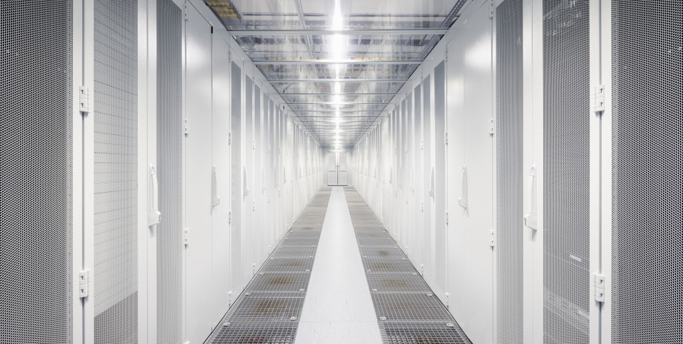 Blick in einen hellbeleuchteten Serverraum mit silbernen Schränken.