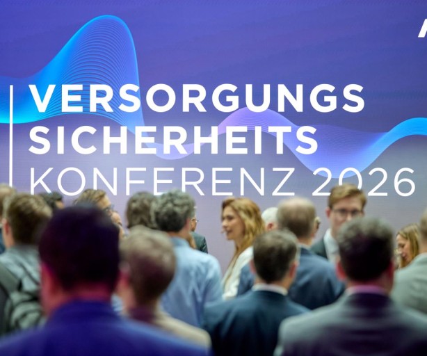Menschenmenge vor einer Wand mit dem Schriftzug VERSORGUNGS SICHERHEITS KONFERENZ 2026