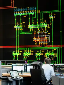Es folgt eine Bildbeschreibung
Das Foto im Querformat stammt aus der Systemführung und  zeigt eines der wichtigsten Arbeitsmittel der Systemführung/Netzführung: das 18 Meter breite und sechs Meter hohe Rückmeldebild. Die neue Hauptschaltleitung von Amprion in Brauweiler bei Köln ist eine der modernsten Warten weltweit. 
Ende der Bildbeschreibung