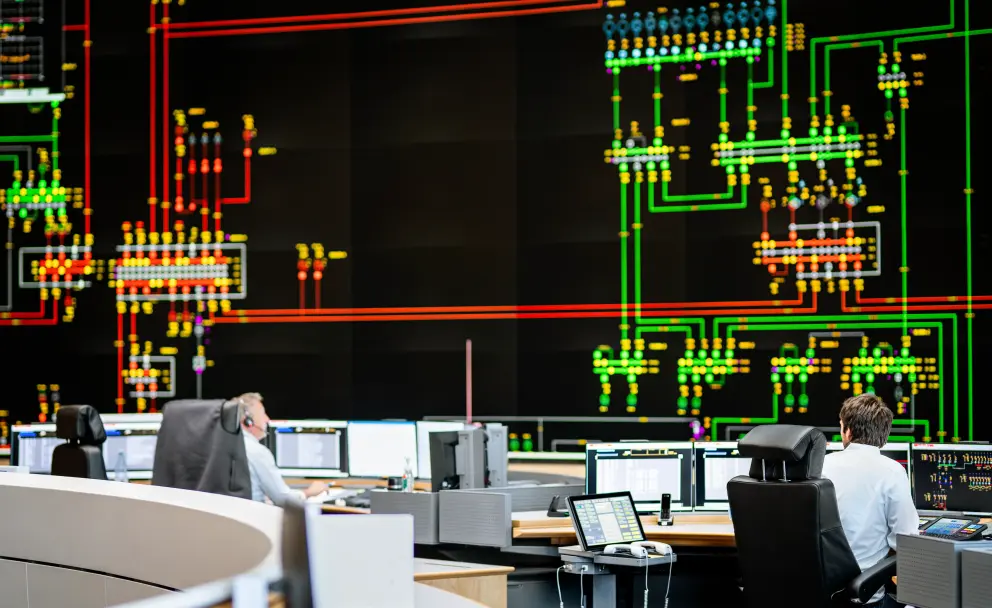 Es folgt eine Bildbeschreibung
Das Foto im Querformat stammt aus der Systemführung und  zeigt eines der wichtigsten Arbeitsmittel der Systemführung/Netzführung: das 18 Meter breite und sechs Meter hohe Rückmeldebild. Die neue Hauptschaltleitung von Amprion in Brauweiler bei Köln ist eine der modernsten Warten weltweit. 
Ende der Bildbeschreibung