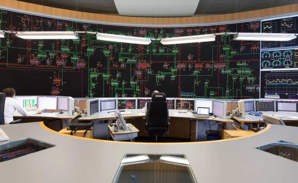 Es folgt eine Bildbeschreibung
Das Foto im Querformat stammt aus der Systemführung und  zeigt eines der wichtigsten Arbeitsmittel der Systemführung/Netzführung: das 18 Meter breite und sechs Meter hohe Rückmeldebild. Die neue Hauptschaltleitung von Amprion in Brauweiler bei Köln ist eine der modernsten Warten weltweit. 
Ende der Bildbeschreibung