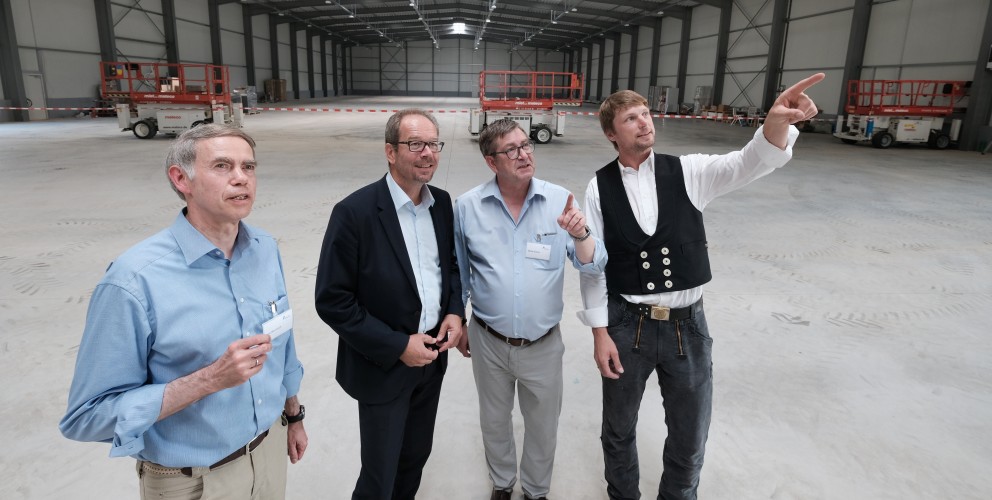 Das Bild zeigt Teilnehmer des Richtfestes in einer Halle in Bergheim. Dirk Bannach (Amprion, Leiter Anlagen), Volker Mießeler (Bürgermeister Bergheim), Detlef Schulz (Amprion, Leiter Logistik) und Polier Thomas Tebbel (Arge Knoll Lamers).