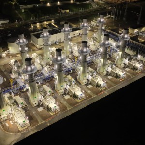 Das Luftbild zeigt ein beleuchtetes Kraftwerk bei Nacht.
Details:
Mehrere hoch aufragende Turbinen oder Transformatoren sind sichtbar.
Die Anlage ist durch zahlreiche helle Lichter beleuchtet.
Im Hintergrund befinden sich Industriegebäude und Bahnanlagen.
Die symmetrische Anordnung der Infrastruktur unterstreicht die technische Präzision.
Dieses Bild vermittelt die Komplexität und Wichtigkeit der Strominfrastruktur.