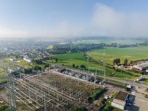 Luftaufnahme mit Blick auf die Umspannanlage Hebertingen von Amprion bei leicht bewölktem blauen Himmel und grünen Feldern im Hintergrund