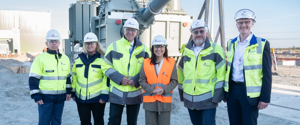 Amprion CEO Christoph Müller, Deutsche Bundesministerin für Wirtschaft und Energie Katherina Reiche und eine Gruppe von Leuten in Schutzkleidung