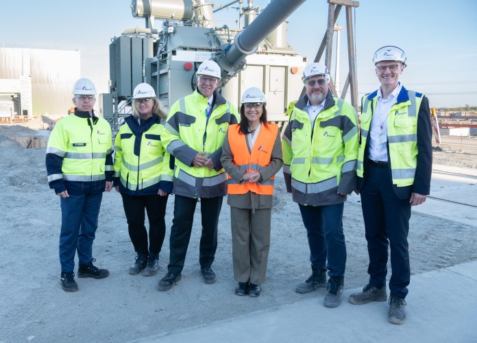 Amprion CEO Christoph Müller, Deutsche Bundesministerin für Wirtschaft und Energie Katherina Reiche und eine Gruppe von Leuten in Schutzkleidung