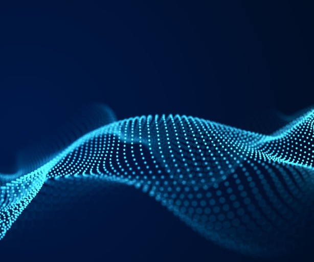 Das Bild zeigt eine abstrakte, digitale Welle, die aus zahlreichen kleinen, leuchtend blauen Punkten besteht. Die Punkte sind zu einer dreidimensionalen, dynamischen Form angeordnet, die sich horizontal über das Bild zieht. Sie erinnern an eine schwingende Wellenform oder eine Datenkurve. Der Hintergrund ist ein dunkles, einfarbiges Blau, wodurch die hellen, leuchtenden Punkte deutlich hervorstechen. Die Darstellung wirkt sehr technisch und futuristisch.