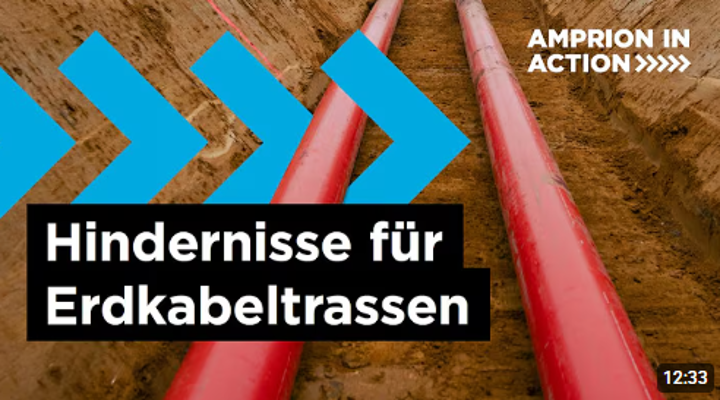 Eine Nahaufnahme einer Baustelle für eine Erdkabeltrasse, die den Blick in einen offenen Graben fokussiert.
Zentrale Elemente: Zwei große, parallele, rote Rohre liegen in einer tiefen, schmalen Grube mit erdfarbenen Wänden. Die Rohre dominieren das Bild und verlaufen von unten links nach oben rechts.
Grafische Overlays: Links und oben befinden sich türkisfarbene, pfeilförmige grafische Elemente.
Textinformationen: Im oberen rechten Bereich steht in weißer Schrift "AMPRION IN ACTION >>>>>". Im unteren linken Bereich befindet sich ein großer schwarzer Balken mit der weißen Aufschrift "Hindernisse für Erdkabeltrassen". Unten rechts ist in einem kleinen schwarzen Kasten die Zeitangabe "12:33" zu sehen.
Hintergrund: Der Hintergrund besteht aus der braunen Erde des Grabens.
