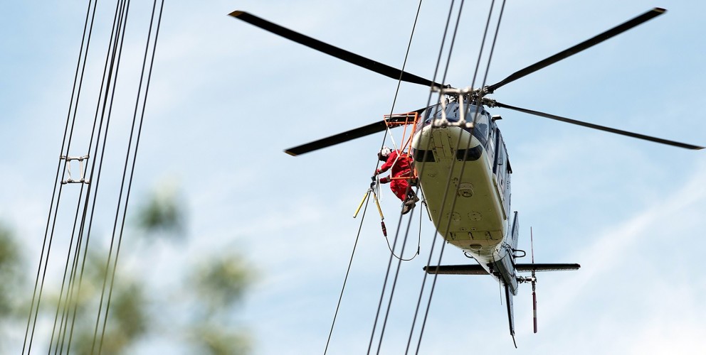 Ein Hubschrauber in unmittelbarer Nähe der Leitung.