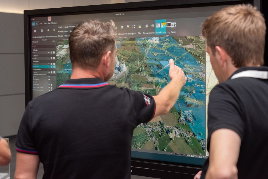 Zwei Personen stehen vor Bildschirm mit 3-D-Ansicht des Projektgebiets von Korridor B