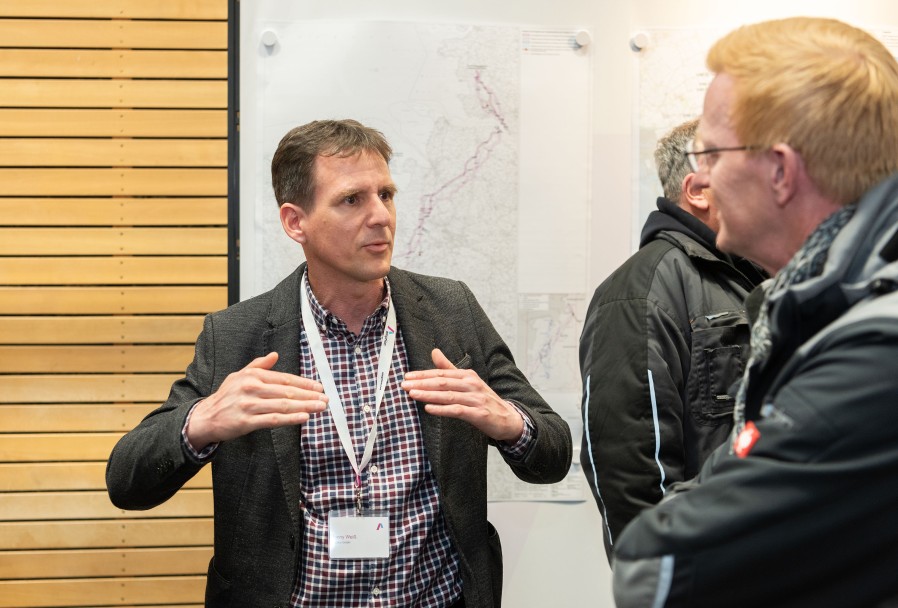 Gesprächssituation zwischen zwei Personen: Einer hält die Hände in einer veranschaulichenden Geste vor dem Körper. Er scheint etwas zu erklären.