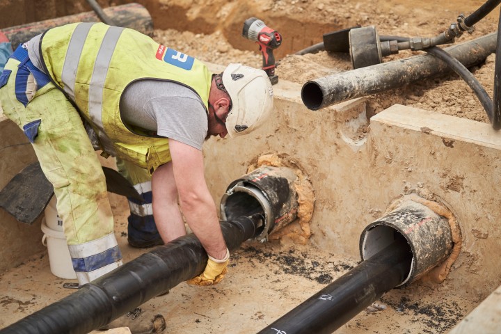 Ein Baustellenmitarbeiter hält das Kabel beim Einzug im offenen Graben
Foto: Frank Peterschröder