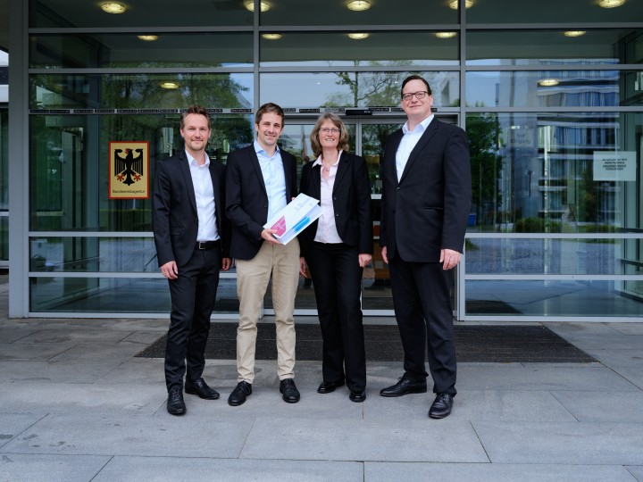 Fabian Hambüchen (Bundesnetzagentur), Dirk Hensen (Amprion), Ines Reichel (Bundesnetzagentur) und Arndt Feldmann (Amprion) bei der Übergabe der Antragsunterlagen