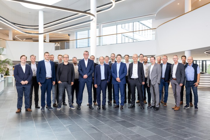 Gruppenbild von 23 Personen, die alle einen Anzug tragen 