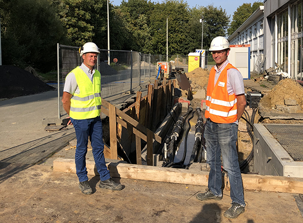 Die Projektleiter Ingo Sander (Amprion, links) und Dirk Wellens (Elia) treffen sich an der deutsch-belgischen Grenze.