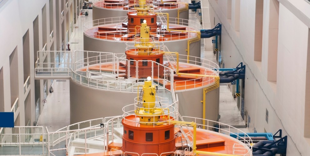  in eine Generatorenhalle. Die Generatoren sind orange.